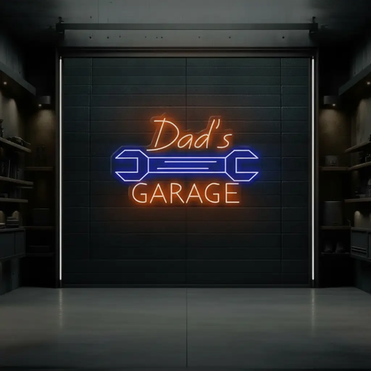 Garage neon sign reading Dad's Garage in orange with a blue wrench on a dark garage wall