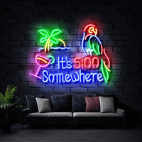 It's 5:00 Somewhere neon sign with palm tree, cocktail and parrot on a dark brick wall above a gray sofa