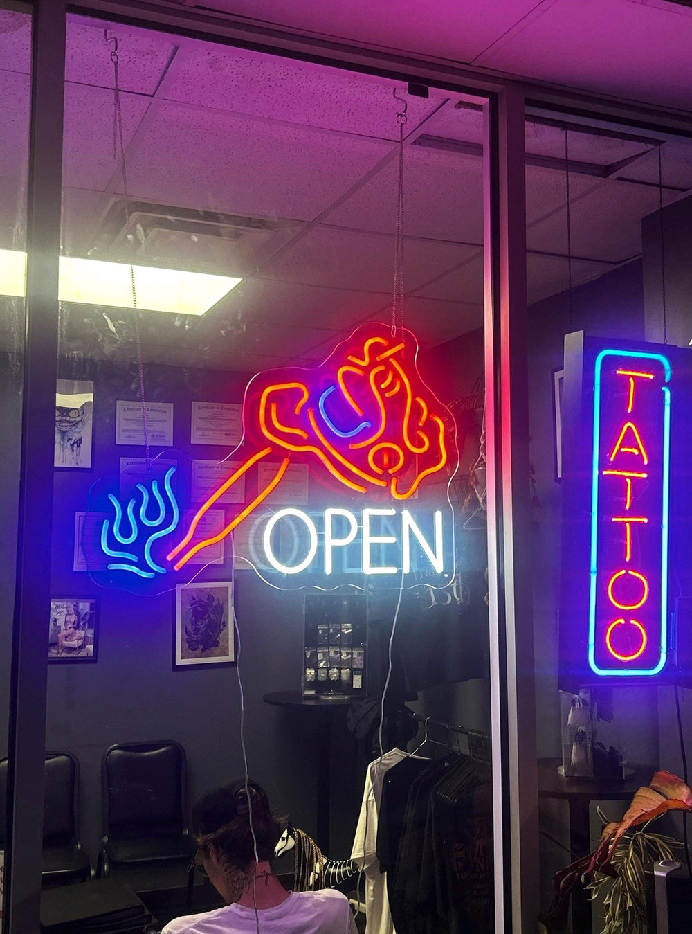 Tattoo and Open LED neon signs in a tattoo shop window