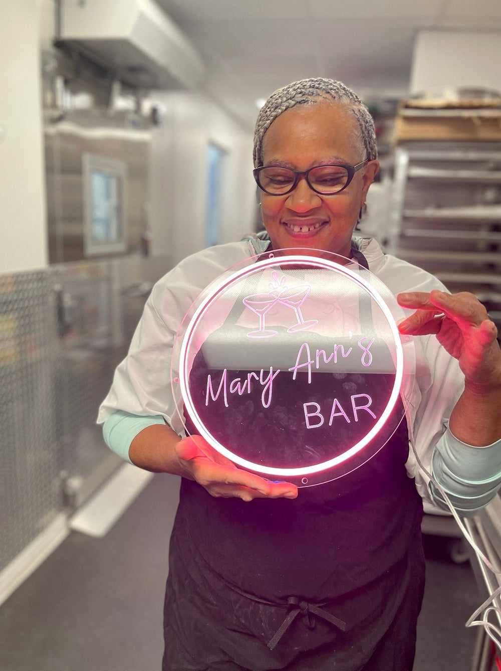 Business owner holding her finished LED neon logo sign