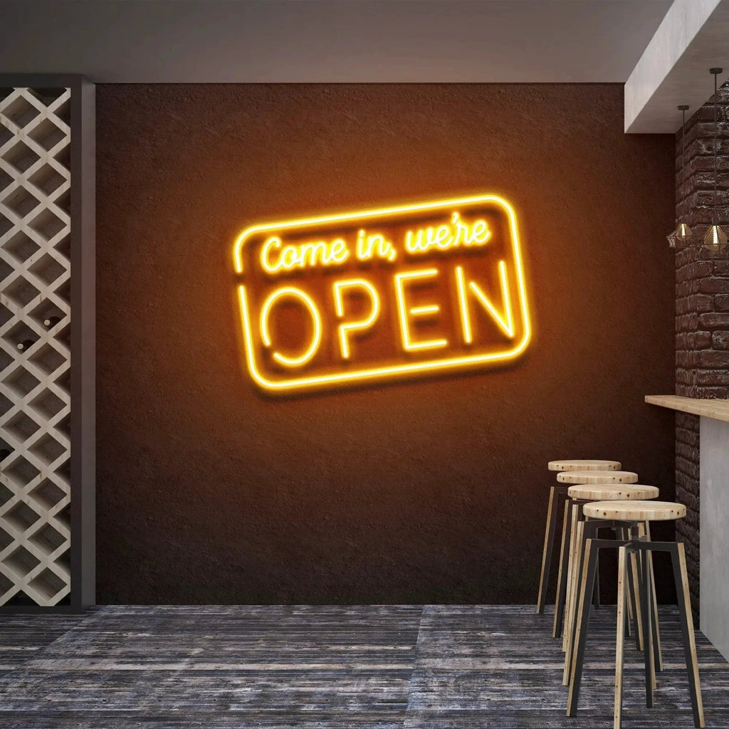 Come In We're Open neon sign glowing orange above bar stools