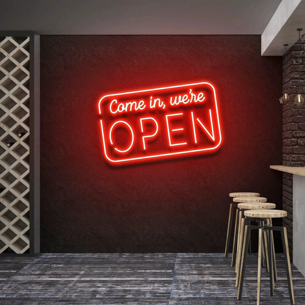 Come In We're Open neon sign glowing red above bar stools